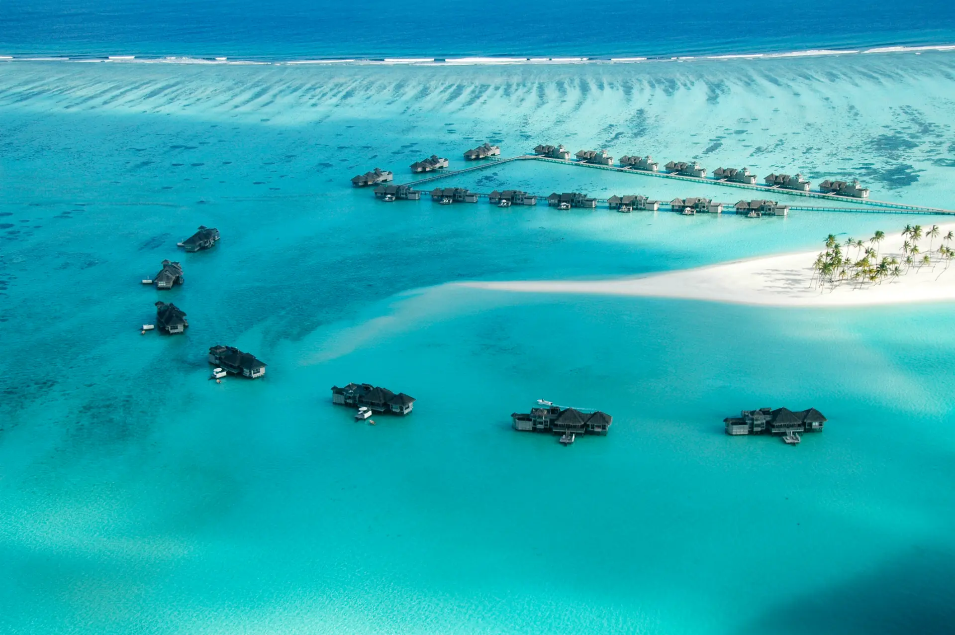 Aerial view of overwater villas across a turquoise lagoon